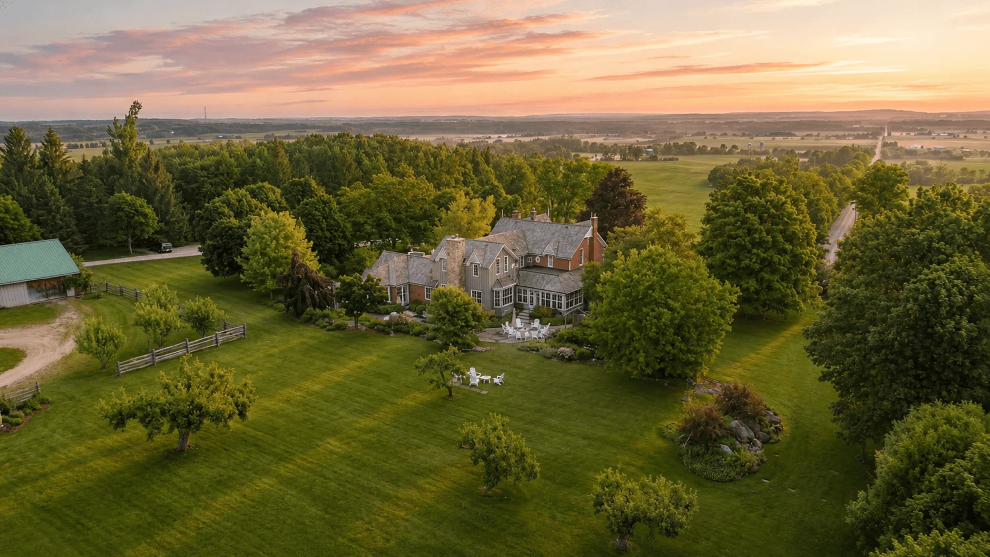 Golden evening light over the farmhouse, gardens and surrounding countryside at Fairview Farm